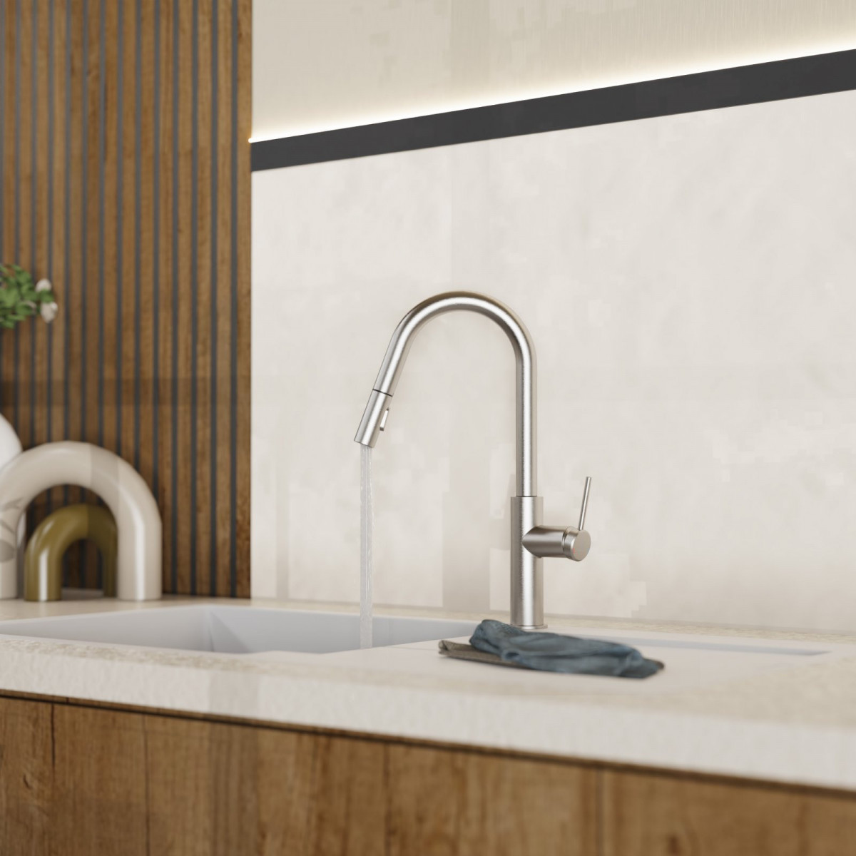 Wasserhahn aus Edelstahl über weißem Spülbecken mit laufendem Wasser und Tuch am Rand.