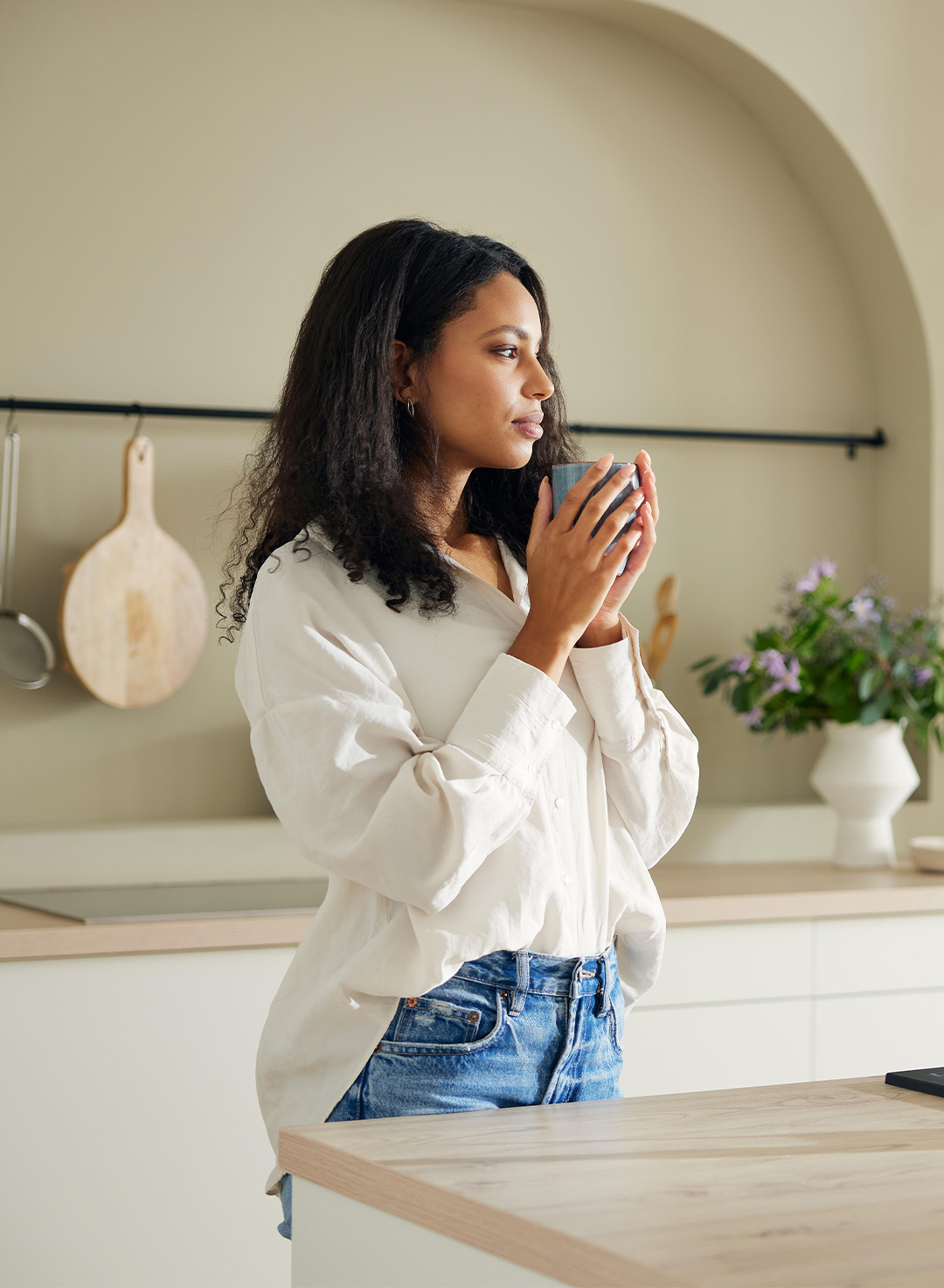 Une femme boit un café dans la cuisine