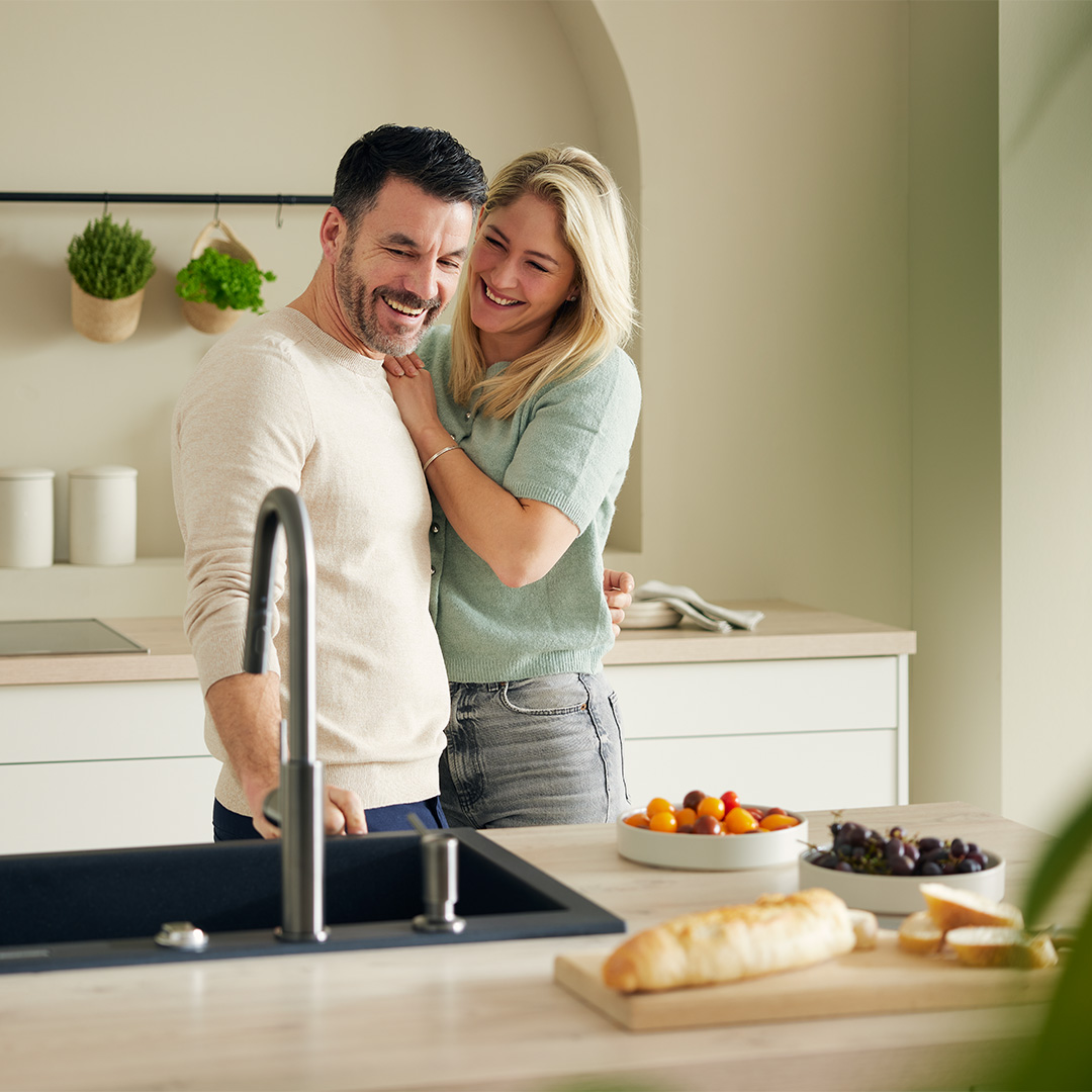 couple standing in kitchen laughing
