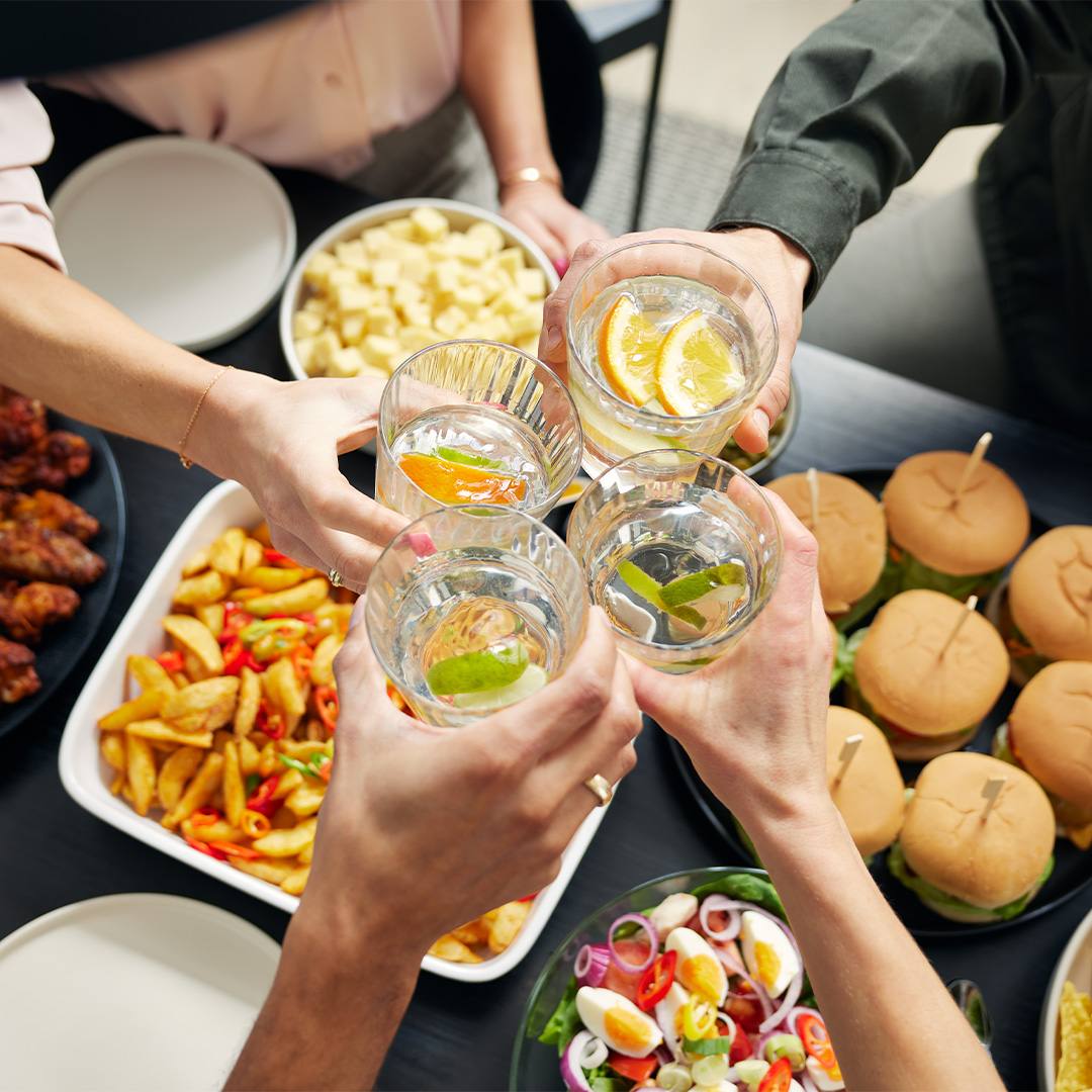 Friends clink glasses while eating