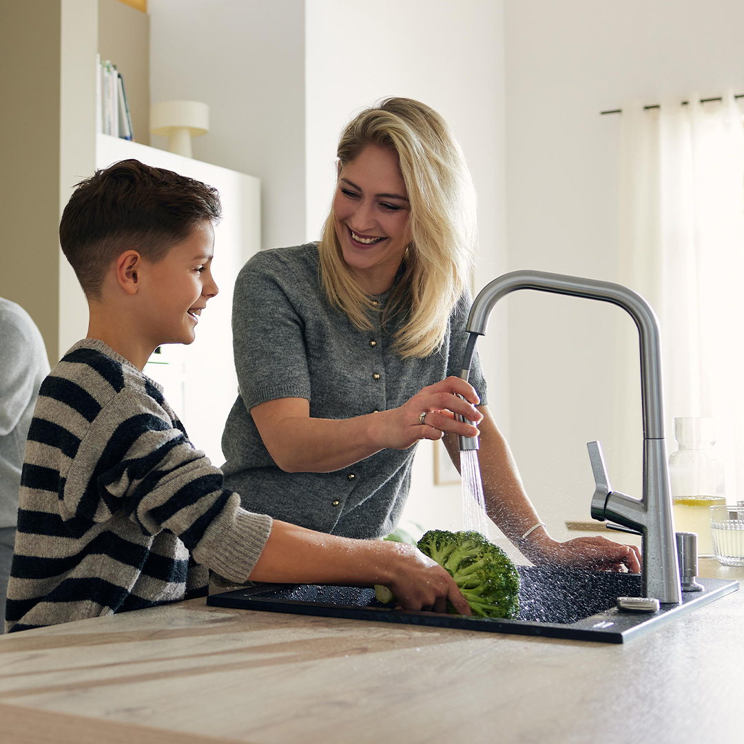 Mother and son washing broccoli